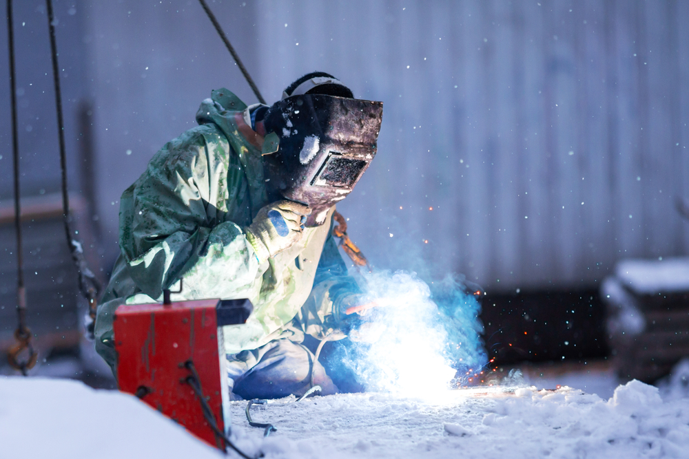 Welder,in,protective,clothing,and,special,protective,mask,performs,welding