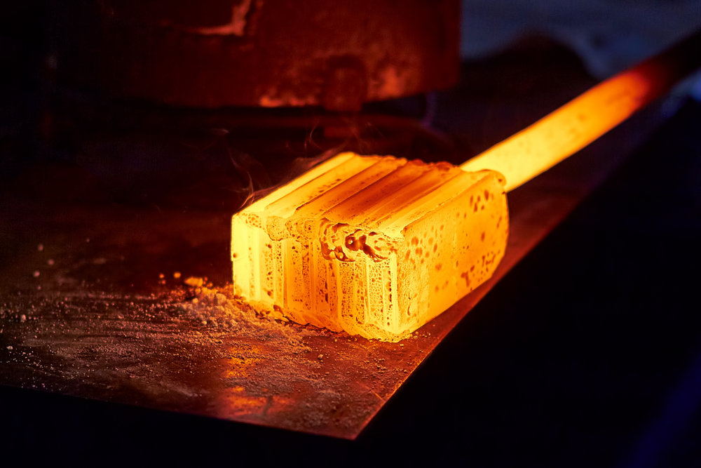 Glowing,iron,ingot,on,the,table.,hot,metal,workpiece,for