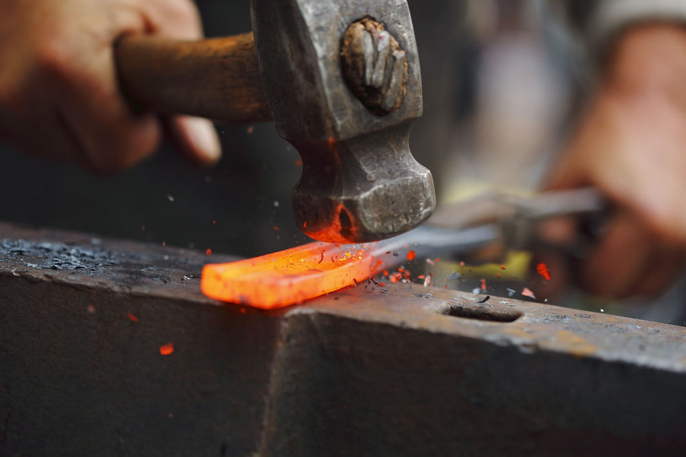 Detail,shot,of,hammer,forging,hot,iron,at,anvil
